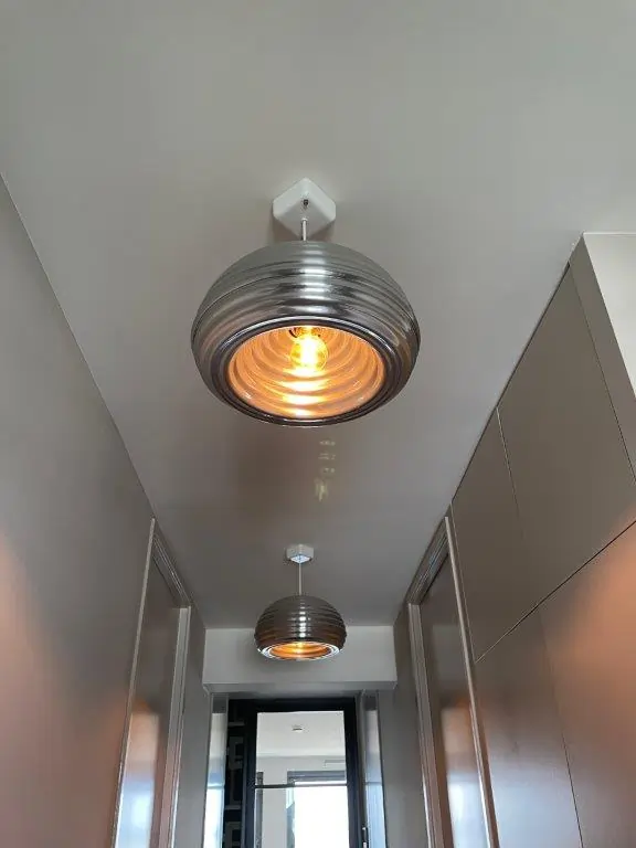 Lamp opgehangen in hal appartement Amsterdam.